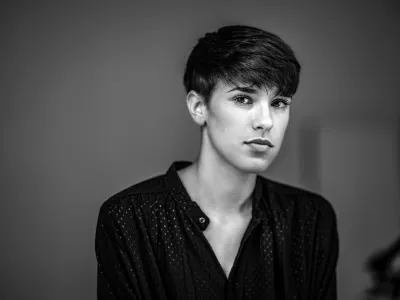 Black-and-white portrait of a young woman with a dark pixie cut in a polka-dot blouse